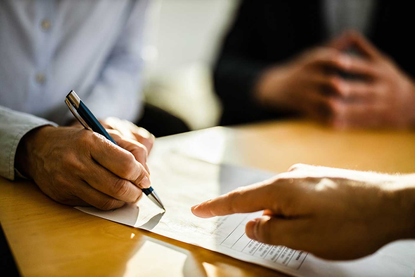 A person signing a piece of paper