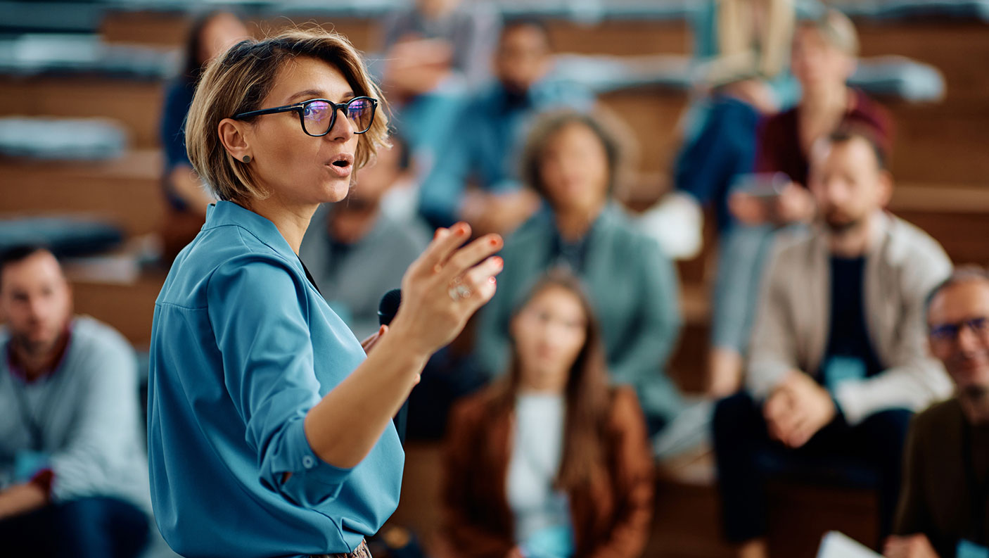 Woman addresses a small crowd of people