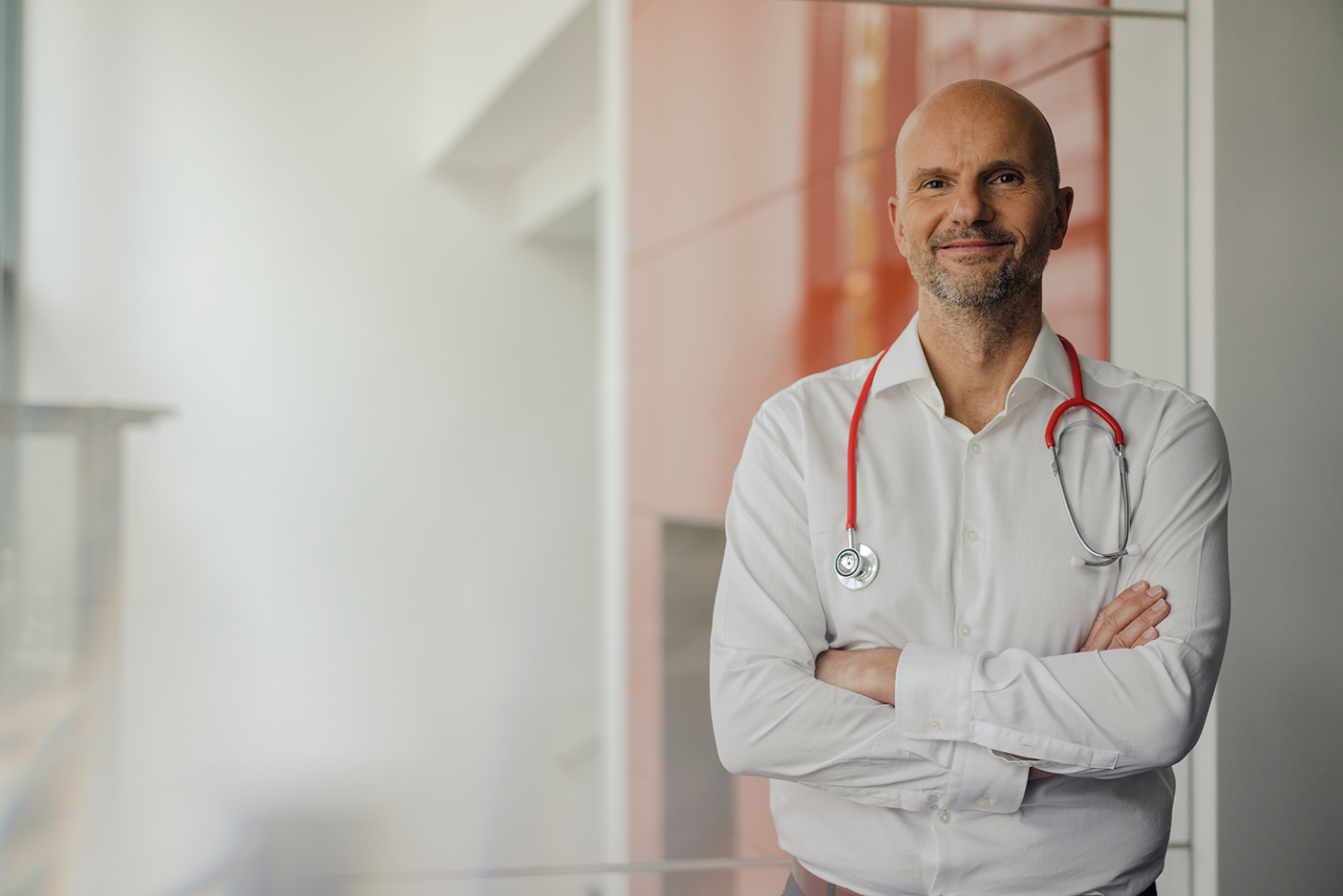 Doctor standing in hospital with stethoscope around his neck - stock photo