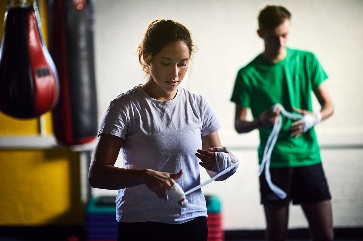 Young male and female boxers wrapping hands in bandages - stock photo