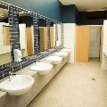 Inside a bathroom and shower area showing basins and taps