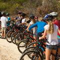 A group of particiants holding bikes listening to an instructor