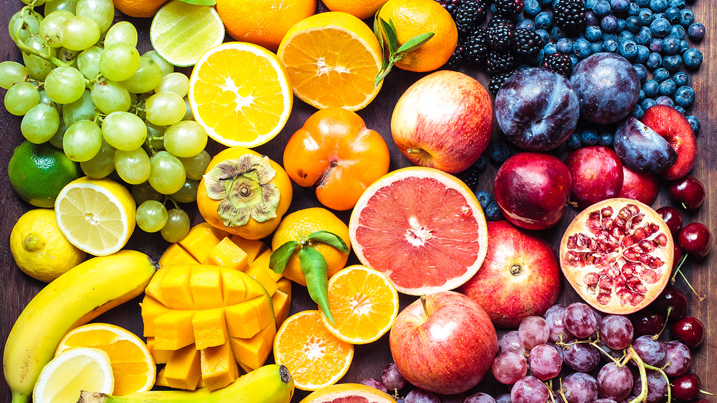 A colourful spectrum of fruit: oranges, lemons, limes, mandarins, grapes, plums, grapefruit, pomegranate, persimmons, bananas, cherries, apples, mangoes, blackberries and blueberries.